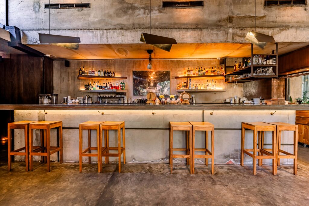 Kilo Seminyak bar interior with warm lighting, spirits on display, and a central bar setup