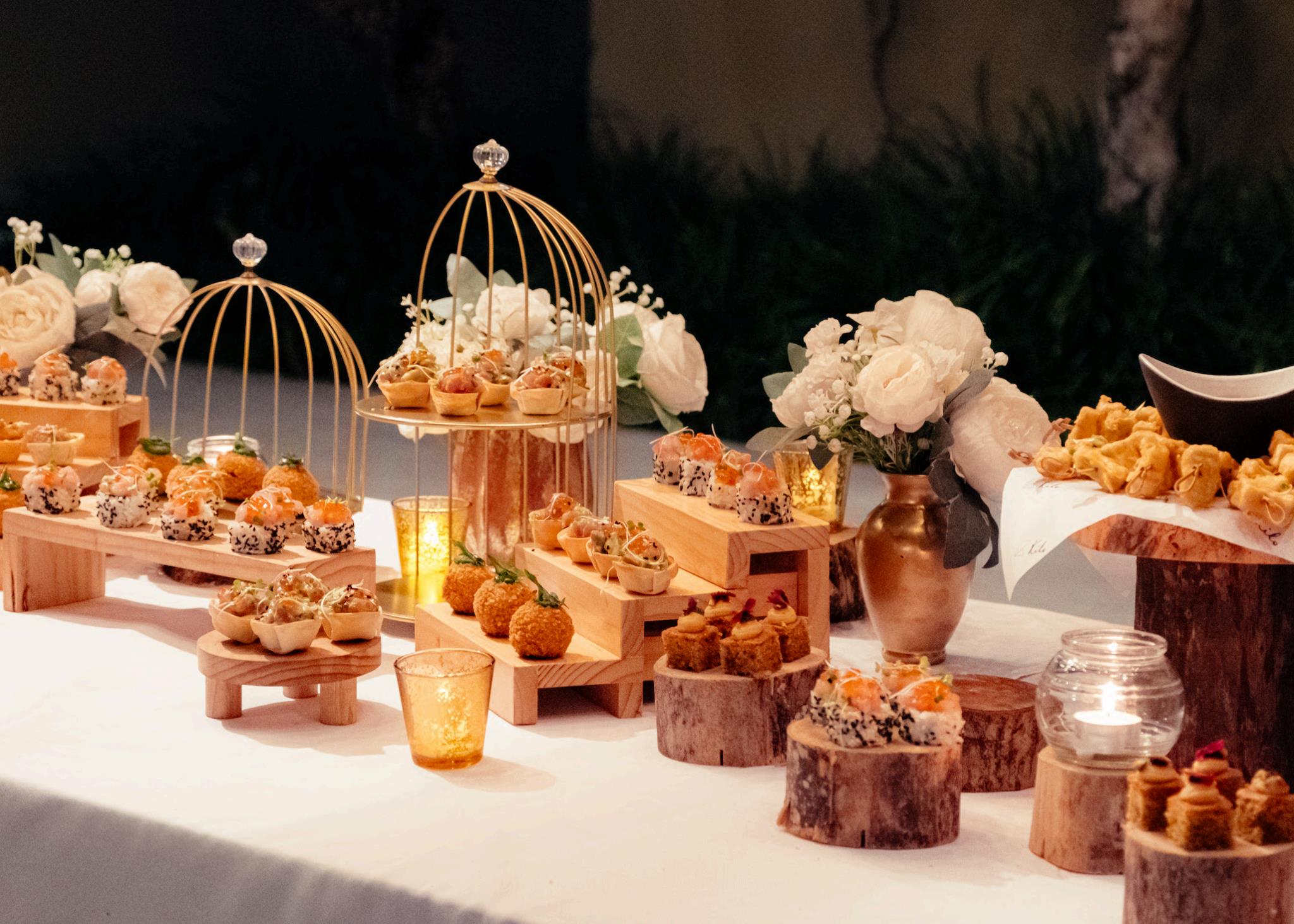 A beautifully arranged table featuring an assortment of desserts surrounded by vibrant flowers.