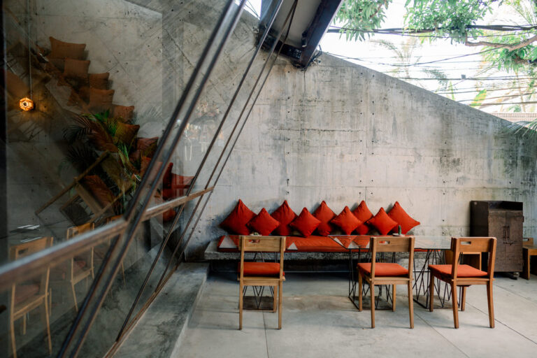 A cozy restaurant featuring vibrant orange pillows and chairs, creating a warm and inviting atmosphere for diners.