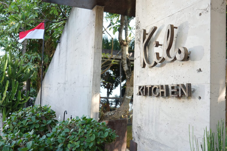 A modern kitchen design featuring sleek cabinetry and tropical decor, set in a Bali-inspired environment.