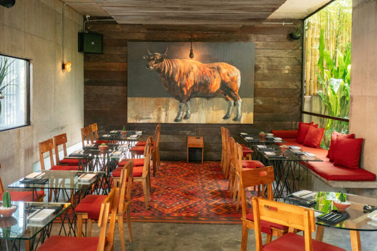 A restaurant interior featuring a prominent painting of a cow displayed on the wall, enhancing the dining atmosphere.