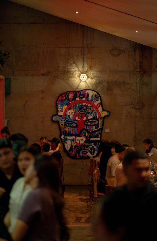 A group of diverse people seated at tables enjoying meals in a lively restaurant atmosphere.