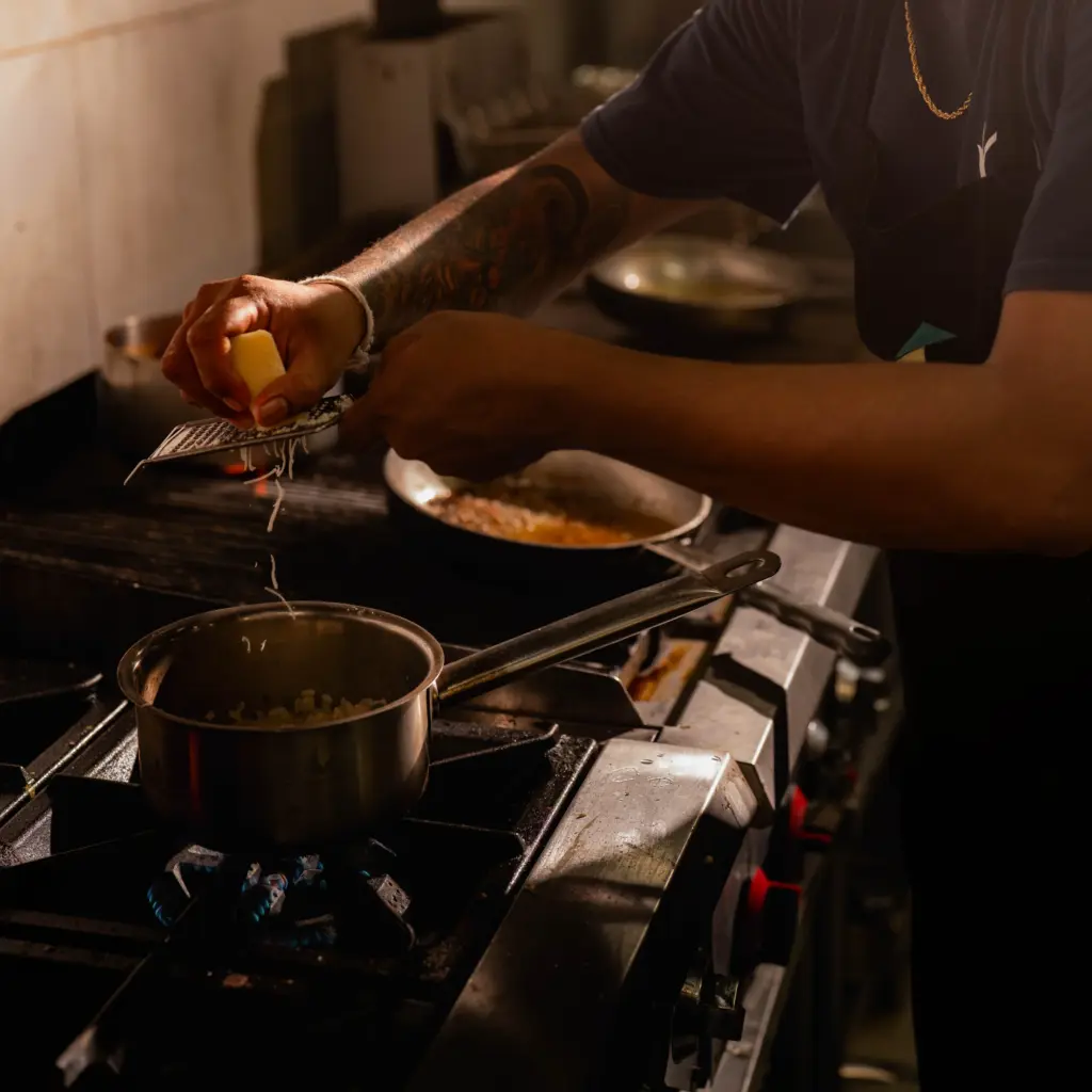 Chef plating a dish in the kitchen at Kilo Kitchen Bali, Seminyak
