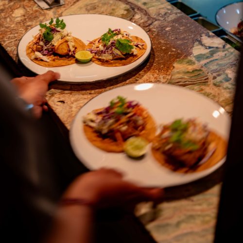 Freshly prepared dishes being served from the kitchen at Kilo Kitchen Bali.