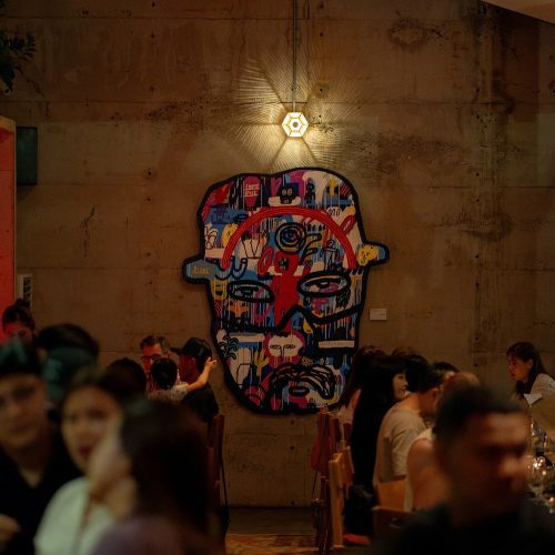 Kilo Kitchen Bali wall art and busy evening crowd, Seminyak Bali