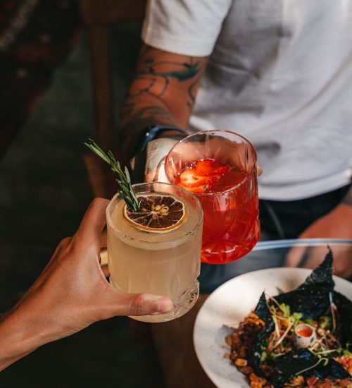 Guests clinking cocktails in a celebratory toast"
