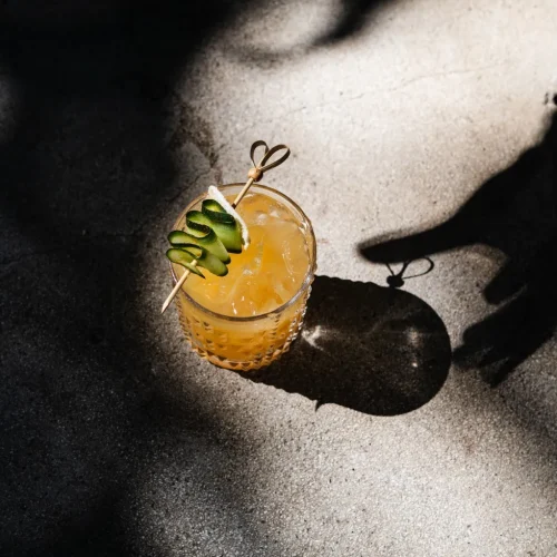 signature cocktails served in stemmed coupe glasses on a wooden bar top at Kilo Seminyak