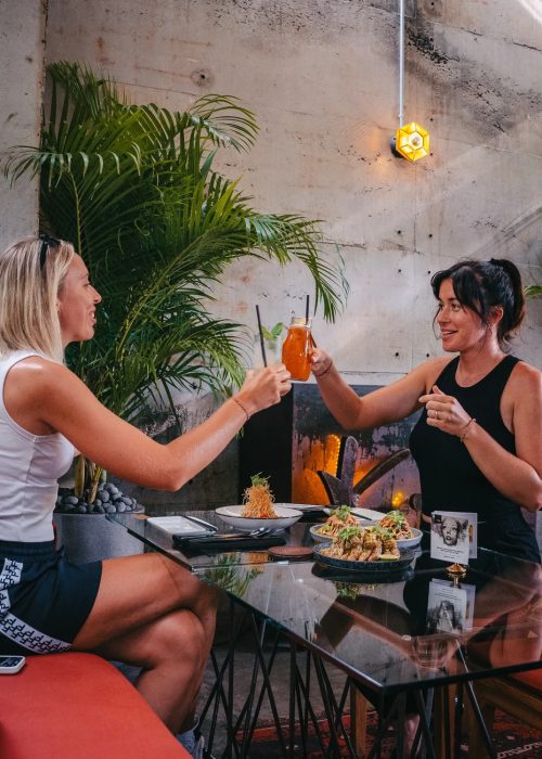 Guests toasting cocktails at Kilo Kitchen Bali outdoor seating, Seminyak restaurant